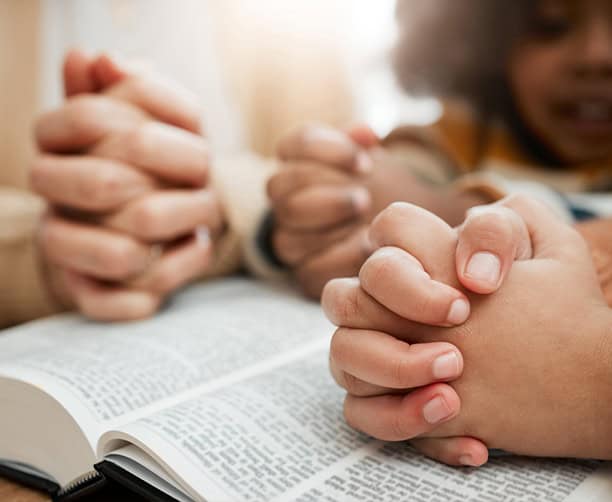 Family Praying Over Bible